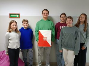 Sześcioro uczniów pozujących do zdjęcia z urną wyborczą.